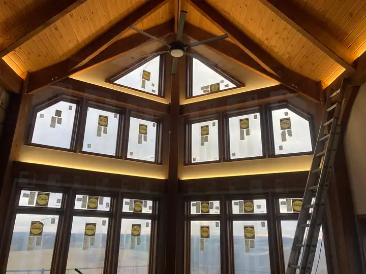 A great room window wall with warm LED cove lighting above and below the glass