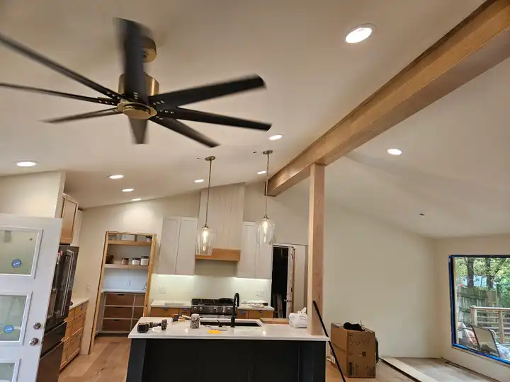 Finished kitchen with a black ceiling fan, pendant lights and recessed lighting wired by Pro Phase Electric