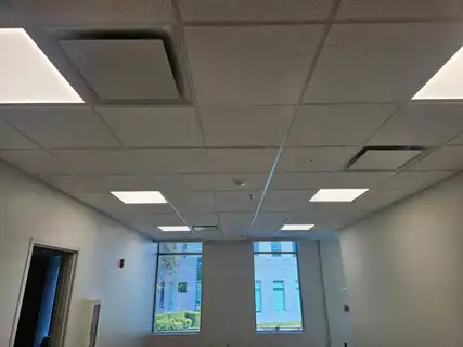 A finished office with recessed ceiling lights and two windows