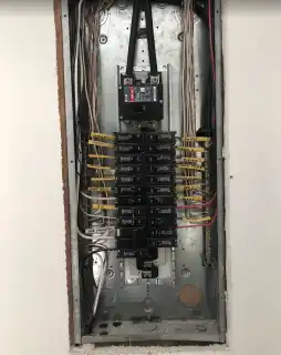 A panel in a wall opening with wiring dressed down both sides
