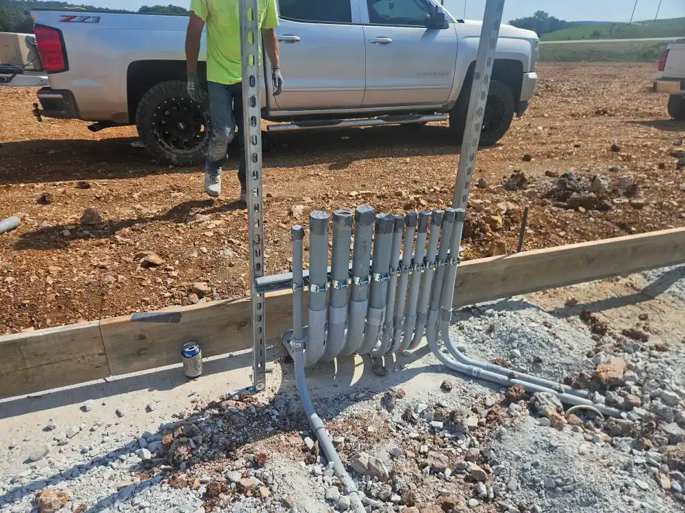 Conduit stub-ups set in the forms before a slab pour, a work truck behind, on a Pro Phase Electric new build