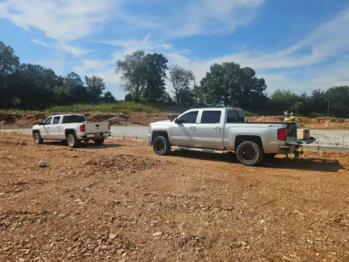 Work trucks parked on a new commercial pad during a Pro Phase Electric new build